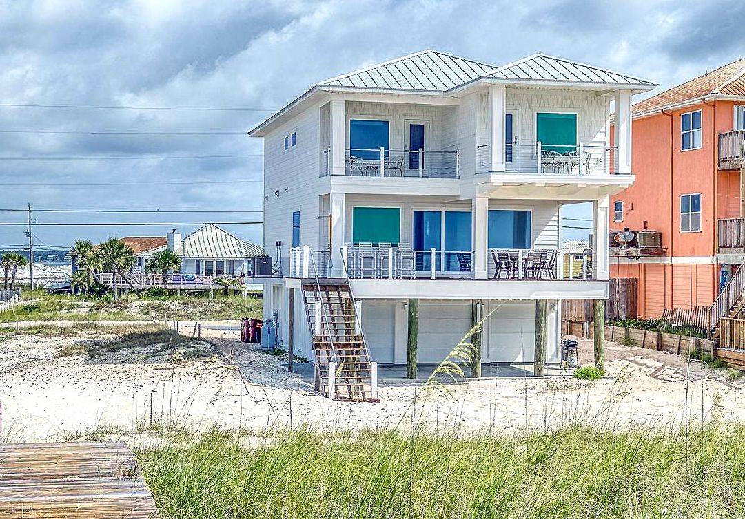 Modern coastal piling home on Navarre Beach by Acorn Fine Homes